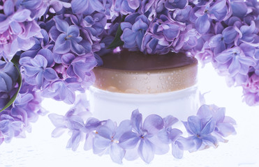 Closeup of jar of moisturizing face cream and flower