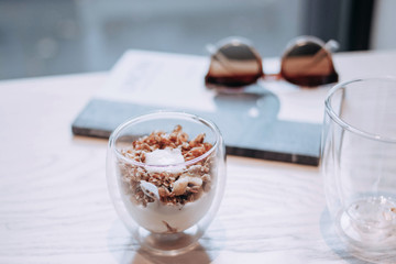 Tasty diet breakfast. Dessert in glasses on a white table. Bright and comfortable interior. Granola in a cup with blueberries and raspberries.