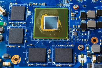 Close up of a printed blue computer circuit board.