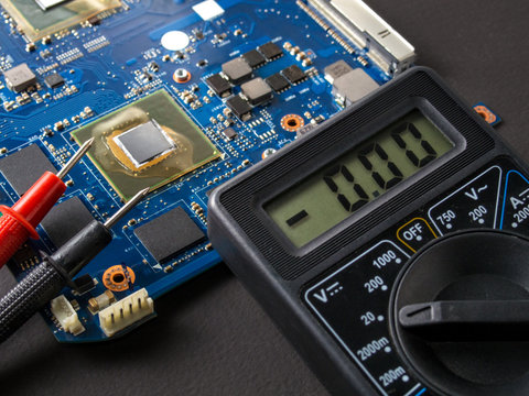 Multimeter test, electronic board of digital device with components. Troubleshoot electronic device. Computer and mobile device repair concept.