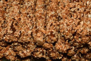 Cevizli sucuk made by dipping a string with walnuts into a grape molasses mixture