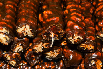 Cevizli sucuk made by dipping a string with walnuts into a grape molasses mixture