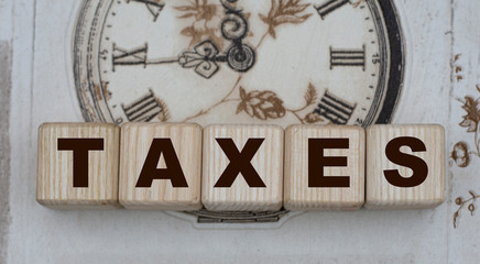TAXES word on cubes on a background of drawn vintage watches