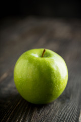 Close-up green apples on the rustic wooden background. Selective focus. Shallow depth of field.
