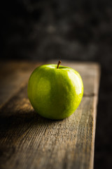 Close-up green apples on the rustic wooden background. Selective focus. Shallow depth of field.
