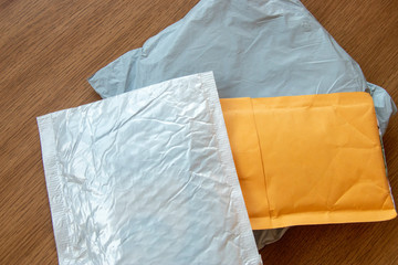 Three postal parcels small package white, gray and yellow on wooden background surface