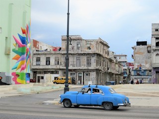Traditional antique cuban blue car driving through the street of Havana