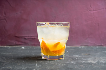 Old fashioned beverage with orange slices on rustic background. Selective focus. Shallow depth of field.