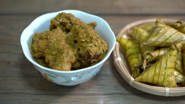 Cinematic shot of ketupat palas and chicken rendang, traditional malay cuisines typically served during eid