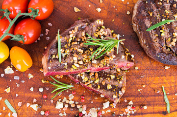 Juicy grilled black angus aged steak with pistachio grain and chopped hazelnuts, cherry tomatoes,...