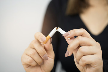 Close-up of a person holding a cigarette in their hand.