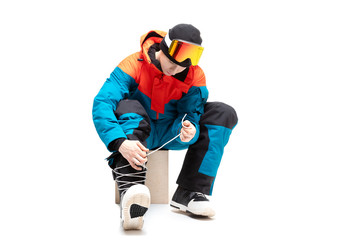 Fototapeta na wymiar Portrait young man in sportswear with snowboard fastens boots isolated white background