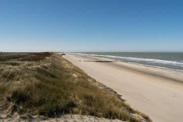 Sand dunes near to the sea with blue sky