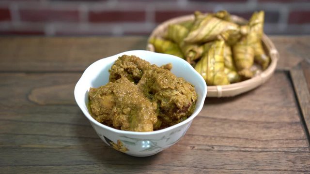 Cinematic shot of ketupat palas and chicken rendang, traditional malay cuisines typically served during eid