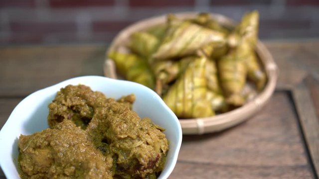 Cinematic shot of ketupat palas and chicken rendang, traditional malay cuisines typically served during eid