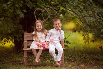 Happy children, brother and sister, friends in nature in a summer park