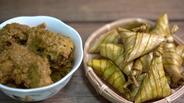 Cinematic shot of ketupat palas and chicken rendang, traditional malay cuisines typically served during eid