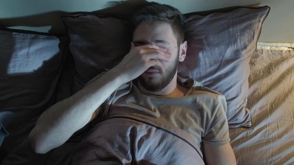Anxiety dream. Unease distress. Man woke up disturbed with nightmares in bed.