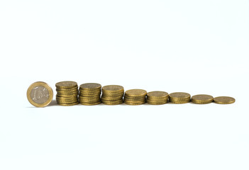 Pila de monedas de 10 céntimos en crecimiento y moneda de euro sobre fondo blanco