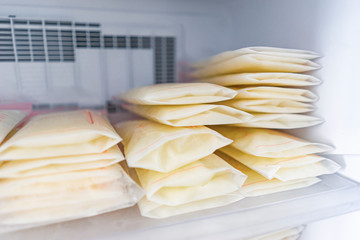 Frozen breast milk packets bags being stored in freezer refrigerator, keeping milk safe from going...
