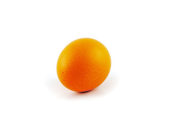 Yellow or orange colored easter egg isolated on white background, colored by easter bunny