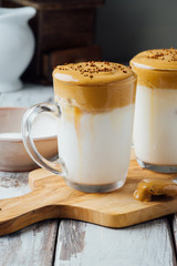 Dalgona coffee or whipped coffee drink with milk on wooden table