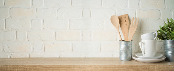 Kitchen background with dishware, utensils, cup, plate and plant on wooden shelf