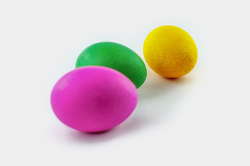 Three easter eggs, red and green, orange or yellow, isolated on white background, colored by easter bunny