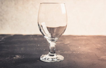 Empty glass on the rustic background. Selective focus.