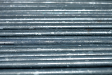 shiny metal pipes stacked in rows