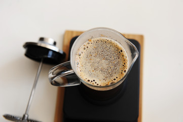 Brewing coffee in french press. Top view close up. White background