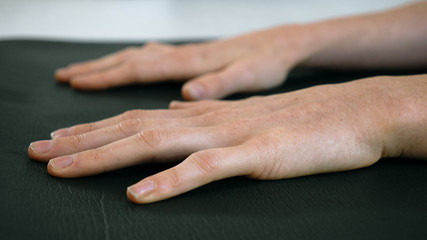 Fototapeta premium Close of hands on yoga mat female