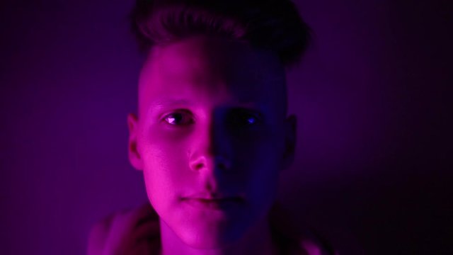 Young teenager in a pink hoodie takes a drug in pills. Tongue guy with lsd wheel