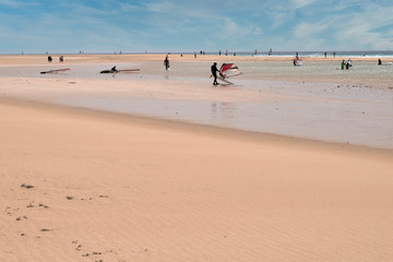 Fototapeta na wymiar Group of surfers learning to surf on the beach shore in Fuerteventura