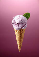 Blueberry ice cream in waffle cone.