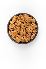 Cleaned Walnuts in round bowl on white background, top view