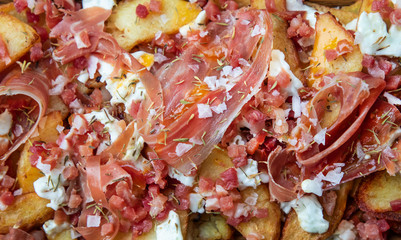 Detail broken eggs with ham and egg and potatoes.
Tapa of restaurant bar in Spain.