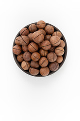 Macadamia nuts in round bowl on white background, top view