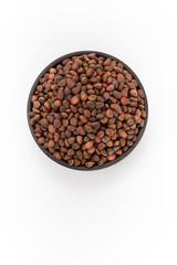 Cedar nuts in round bowl on white background, top view