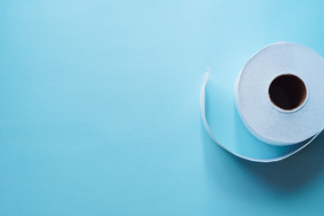 Roll of toilet paper on a pastel blue background coronavirus design