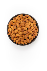 Raw Almonds nuts in round bowl on white background, top view