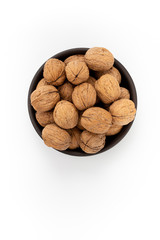 Walnuts in round bowl on white background, top view