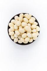 Almonds nuts in yogurt  in round bowl on white background, top view