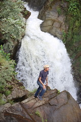 Obraz premium A man climbing Waterfall in Khlong Wang Chao National Park at Kamphaeng Phet, Thailand