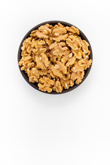 Cleaned Walnuts in round bowl on white background, top view