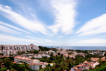 Fototapeta na wymiar Panoramic view of the Spanish coastal city, the sea and with light feather clouds in the sky