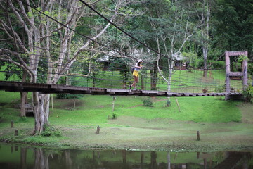 Women on a wooden suspension bridge in Khlong Wang Chao Kamphaeng Phet National Park, Thailand
