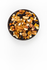 Dried mixed fruits and nuts  in round bowl on white background, top view