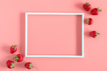 Strawberries on pink background. Blank frame for text, strawberries berries pattern. Creative food...
