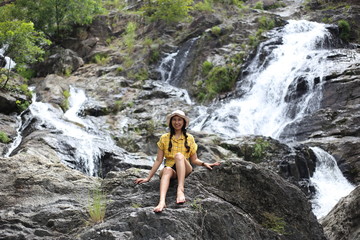 Woman sitting at Khlong Nam Lai waterfall in Klong Lan national park, Kamphaeng Phet, Thailand